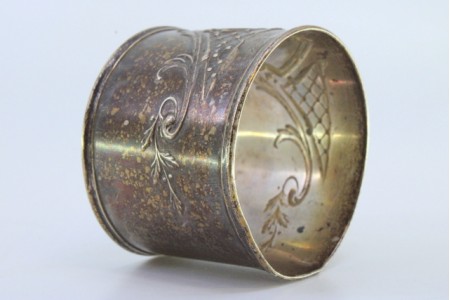 Argola de guardanapo em prata com motivos florais relevados e envolvendo cartela para monograma.